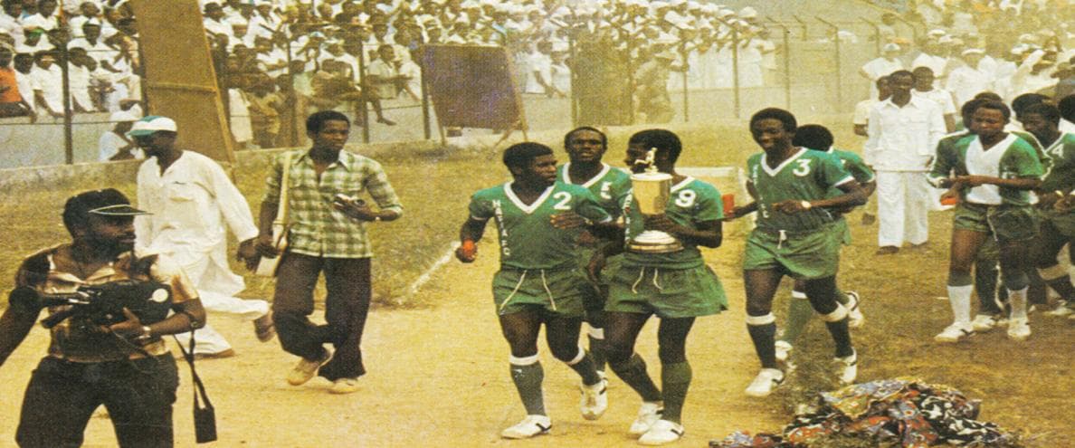Photographie d’archive : les joueurs du Hafia FC portant un trophée, entourés de supporters